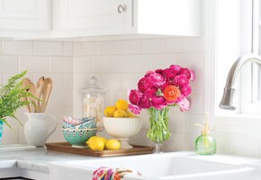 Kitchen bench with bowl of lemons and colourful flowers